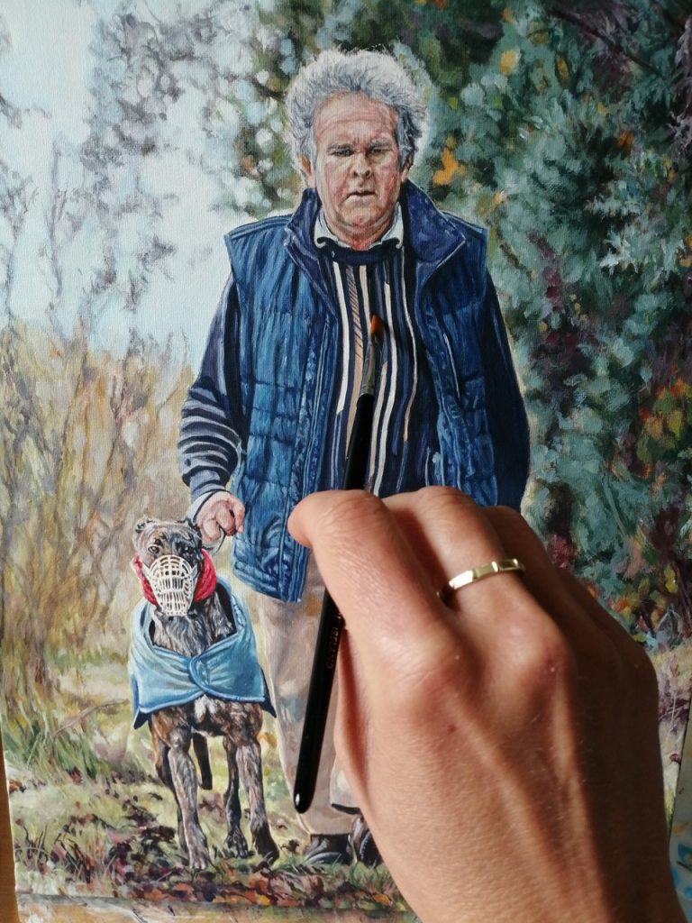 man and greyhound walking adding detail to painting