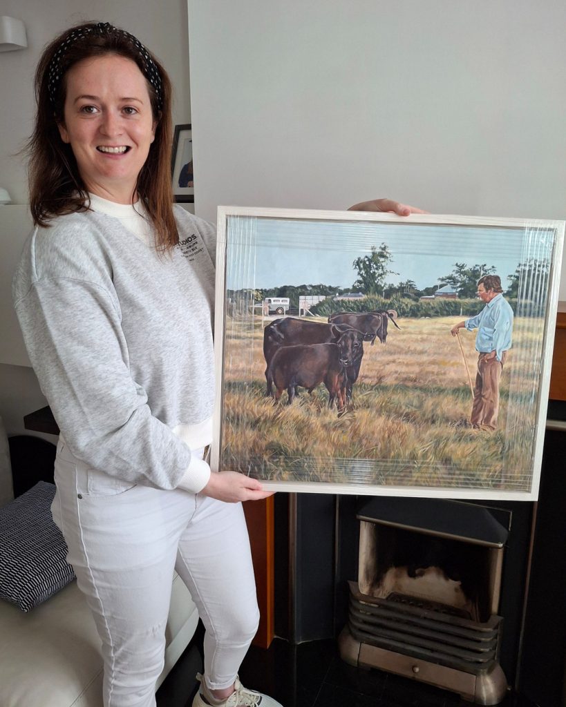 happy client collecting an acrylic farm painting of a man with cattle