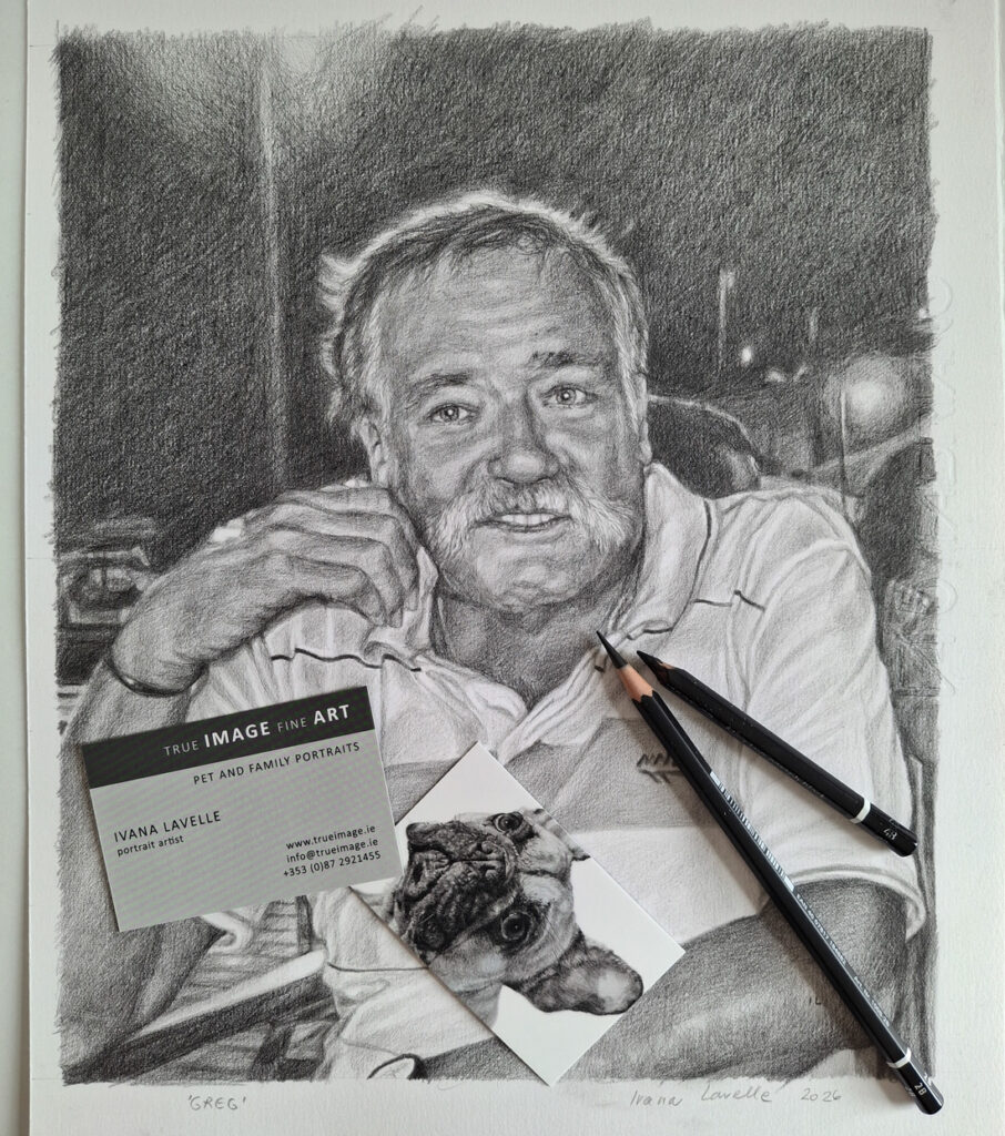 the finished portrait on paper with pencils and business cards