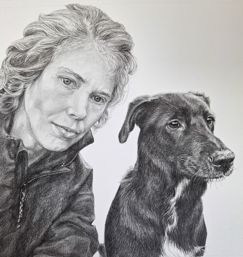 photo of an almost completed portrait drawing of girl and dog