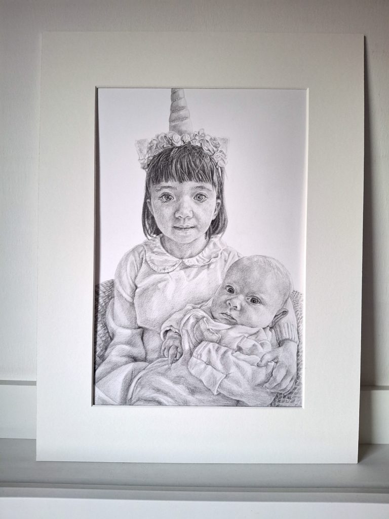 pencil portrait drawing of children mounted in a mount