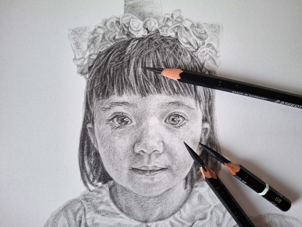 completed pencil drawing of a young girl with pencils