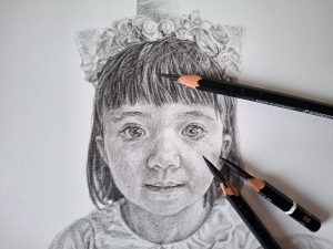 completed pencil drawing of a young girl with pencils
